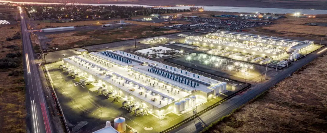 Aerial view of a large European cloud data center campus illuminated at dusk.