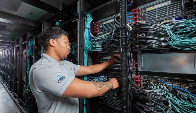 Liquid-cooled supercomputer racks with red and blue coolant lines
